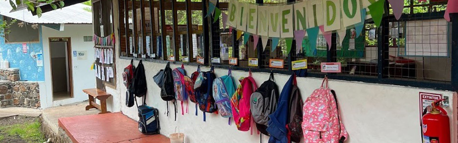 Classroom exterior with the backpacks of students lining the outside wall.
